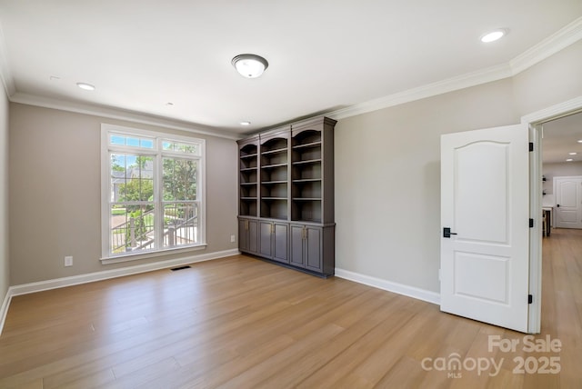 unfurnished room with light wood-type flooring, visible vents, and baseboards