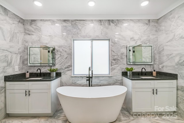 bathroom featuring ornamental molding, a freestanding tub, a sink, and marble finish floor