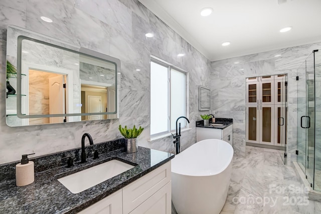 full bathroom with a freestanding tub, two vanities, a sink, marble finish floor, and a stall shower