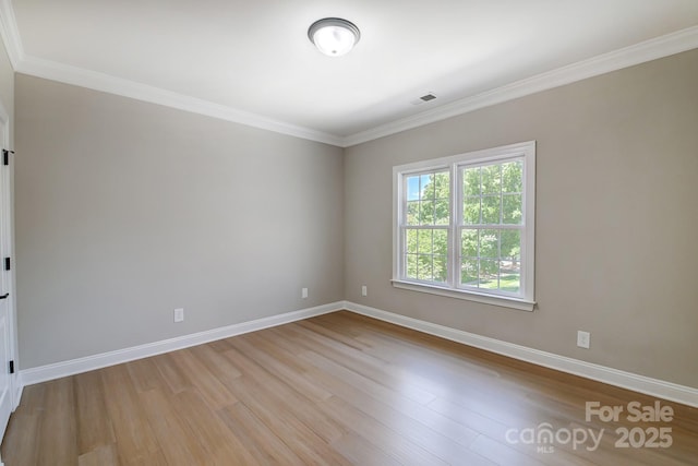 unfurnished room with crown molding, light wood finished floors, and baseboards