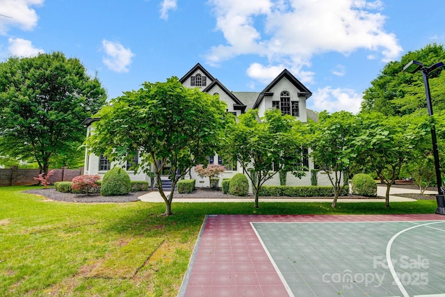 view of sport court featuring a lawn, fence, and basketball court