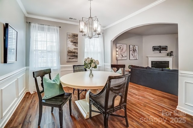 dining room featuring visible vents, dark wood-type flooring, and ornamental molding