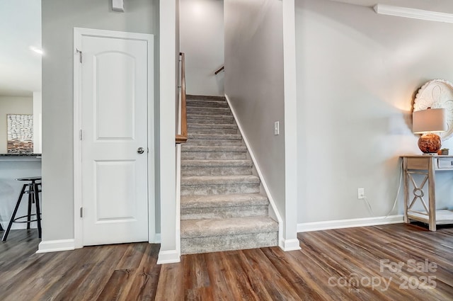 stairway featuring wood finished floors and baseboards