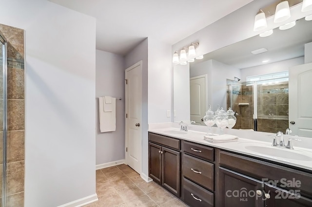 bathroom with double vanity, a stall shower, tile patterned flooring, and a sink