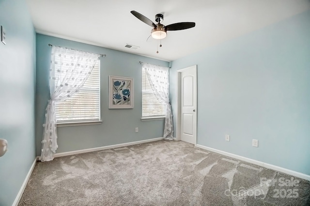 empty room with baseboards, plenty of natural light, visible vents, and carpet flooring