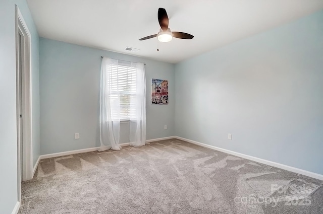 unfurnished room featuring carpet floors, baseboards, visible vents, and a ceiling fan