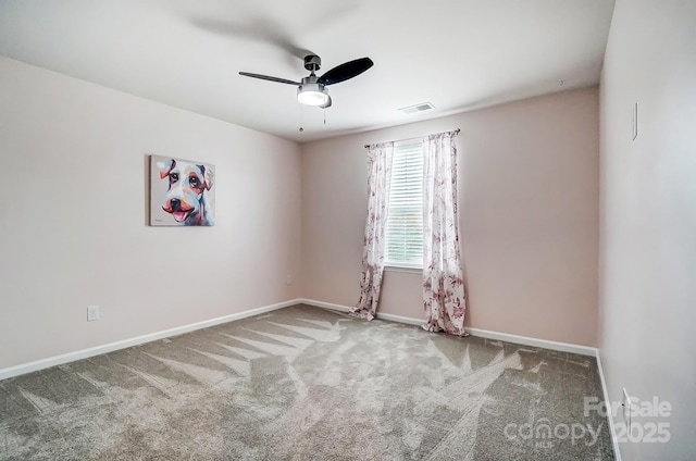 empty room featuring carpet floors, a ceiling fan, visible vents, and baseboards