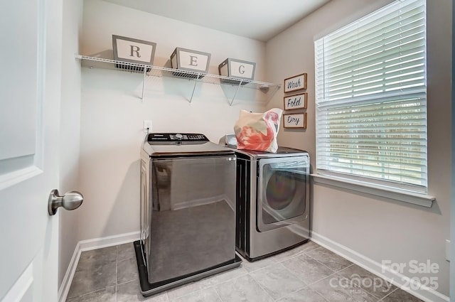 laundry area featuring laundry area, baseboards, separate washer and dryer, and light tile patterned flooring