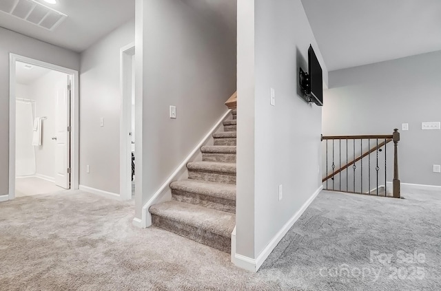 staircase featuring carpet, visible vents, and baseboards