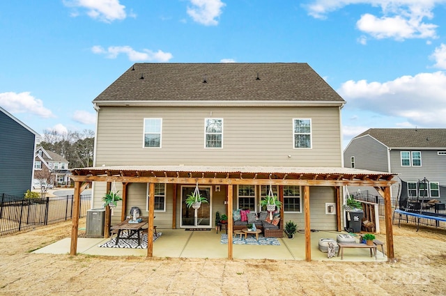 back of property with a trampoline, a patio area, fence, and a pergola