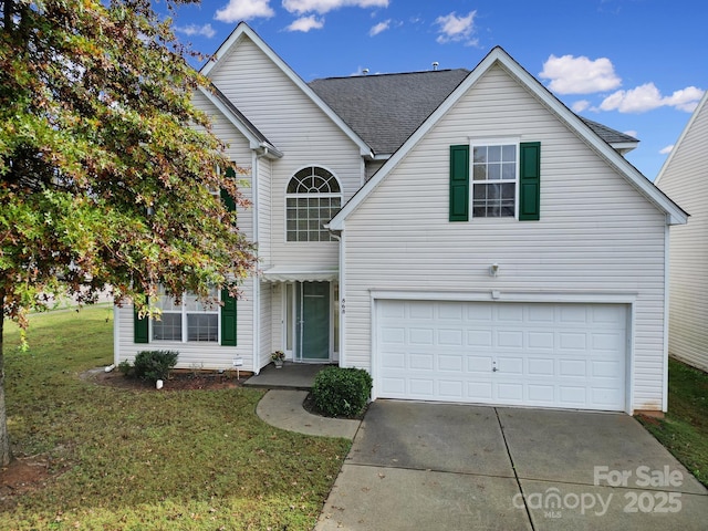 traditional-style home featuring driveway, an attached garage, a shingled roof, and a front yard