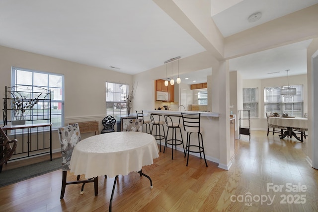 dining area with light wood finished floors and baseboards