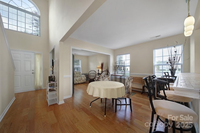 dining area with baseboards, visible vents, and wood finished floors