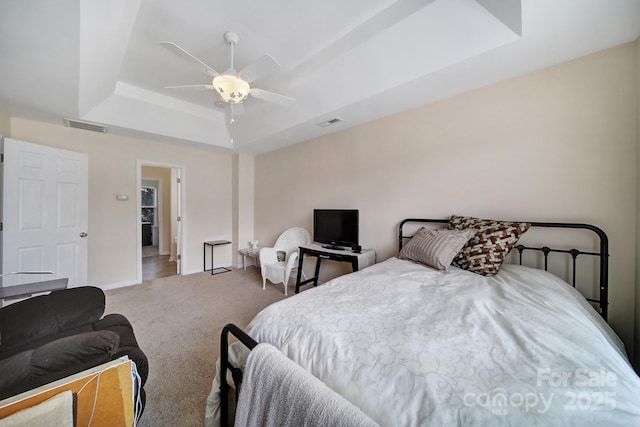 bedroom featuring carpet, a raised ceiling, visible vents, and baseboards