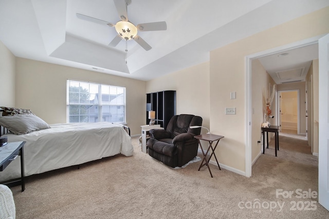 bedroom with light carpet, baseboards, a tray ceiling, and ceiling fan