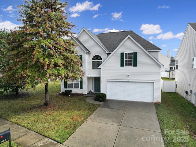 traditional-style house with an attached garage, driveway, a front lawn, and fence