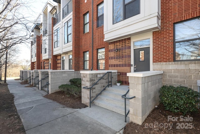 view of exterior entry with brick siding