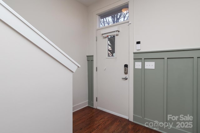 foyer with dark wood-style floors and baseboards