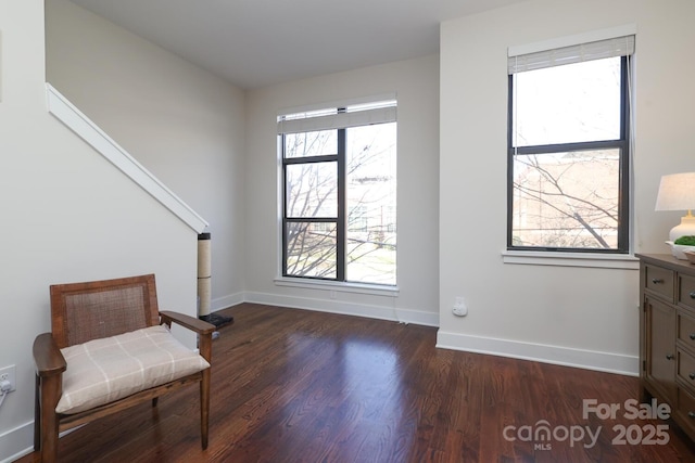 living area with dark wood-type flooring and baseboards