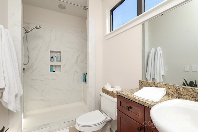 bathroom featuring toilet, a stall shower, and vanity