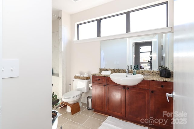 bathroom with toilet, a healthy amount of sunlight, tile patterned flooring, and vanity