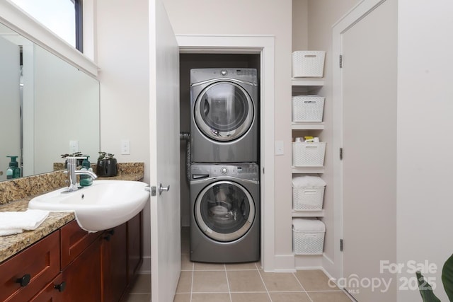 laundry area featuring laundry area, light tile patterned flooring, a sink, and stacked washer / drying machine