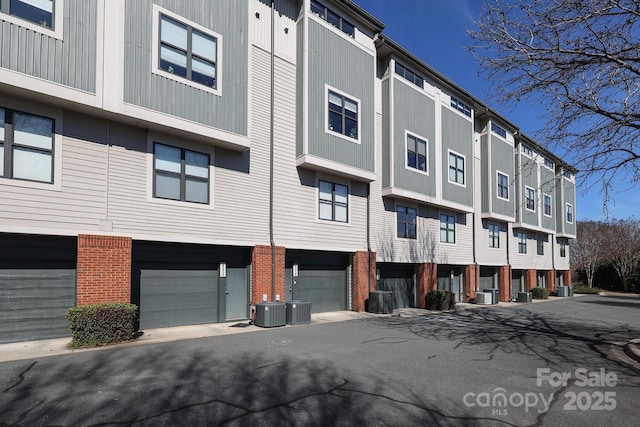 view of building exterior with a garage and central AC unit