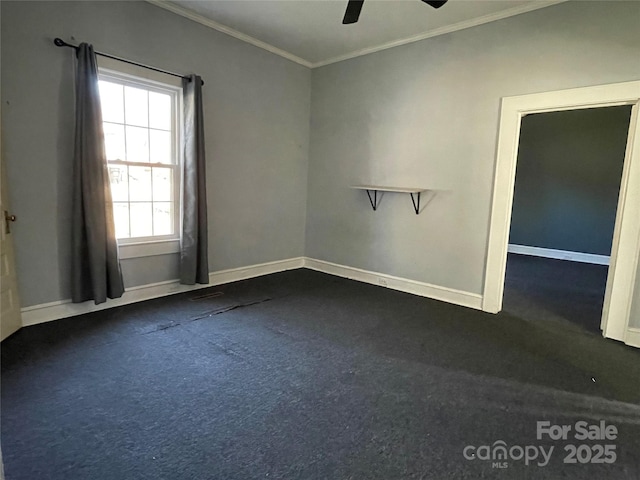 spare room featuring ornamental molding, dark colored carpet, ceiling fan, and baseboards