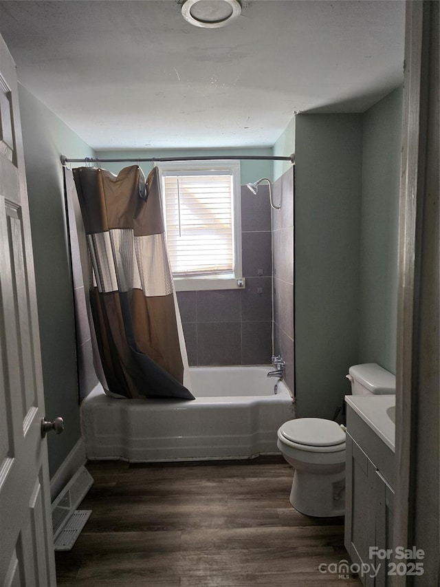 bathroom featuring toilet, shower / bathtub combination with curtain, vanity, and wood finished floors