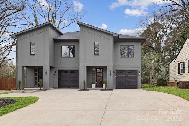 modern home featuring cooling unit, board and batten siding, concrete driveway, and an attached garage