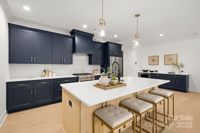 kitchen featuring light countertops, a kitchen breakfast bar, premium range hood, and appliances with stainless steel finishes