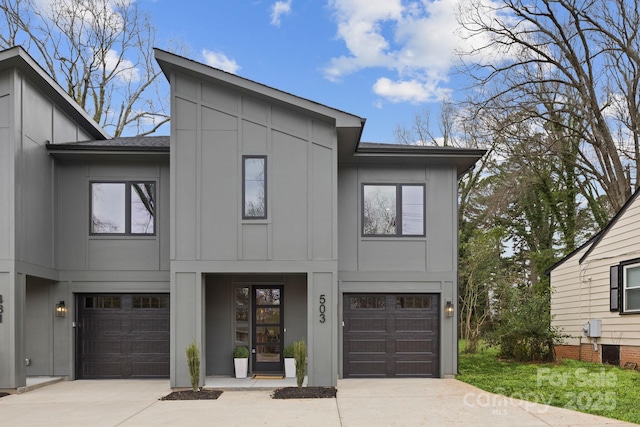 view of front facade featuring an attached garage, board and batten siding, driveway, and a shingled roof