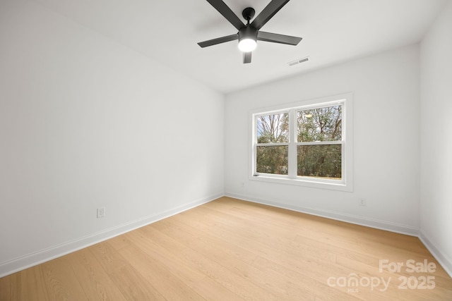 unfurnished room featuring visible vents, light wood-style flooring, baseboards, and a ceiling fan