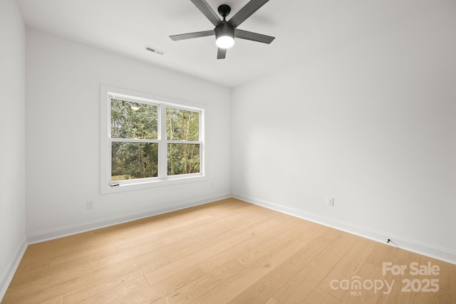 unfurnished room featuring visible vents, light wood-type flooring, and baseboards