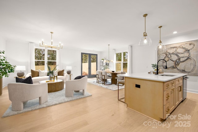 kitchen with open floor plan, light wood-style flooring, french doors, and an inviting chandelier