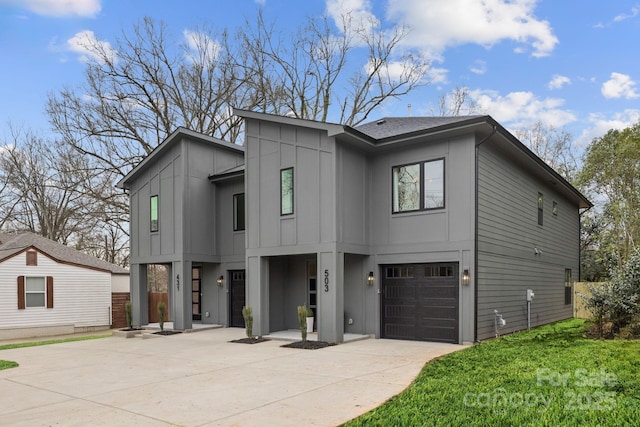 view of front facade with a front lawn, an attached garage, board and batten siding, and driveway