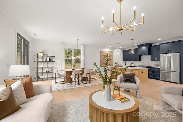 living room with a notable chandelier, recessed lighting, and light wood-style flooring