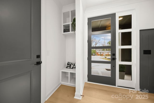 interior space featuring light wood-type flooring, baseboards, and elevator