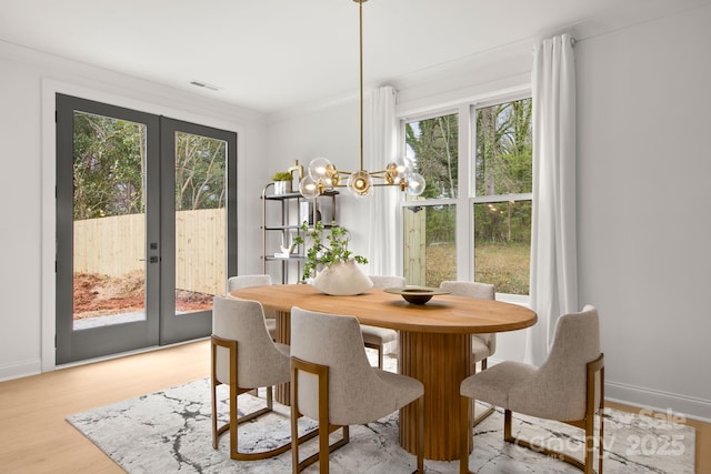 dining room featuring french doors, baseboards, an inviting chandelier, and wood finished floors