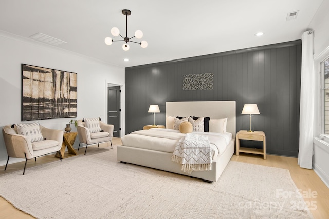 bedroom with crown molding, wood finished floors, visible vents, and a chandelier