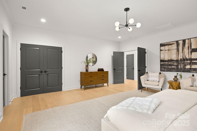 bedroom featuring a chandelier, light wood-style flooring, and crown molding