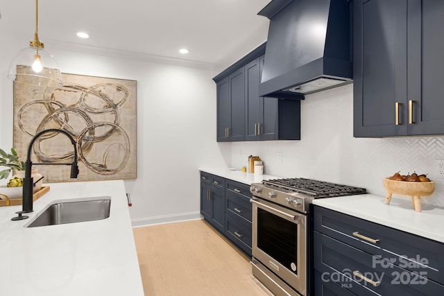 kitchen featuring backsplash, high end stove, premium range hood, light wood-type flooring, and a sink