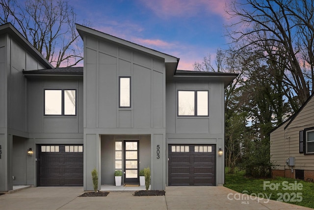 view of front facade featuring a garage, board and batten siding, and driveway