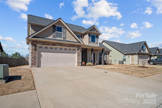 view of front of property with a garage, cooling unit, driveway, and fence