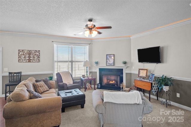 living area with a warm lit fireplace, baseboards, ceiling fan, ornamental molding, and a textured ceiling