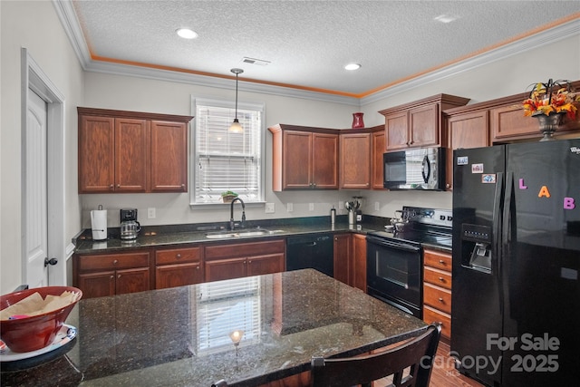 kitchen with crown molding, a textured ceiling, black appliances, pendant lighting, and a sink