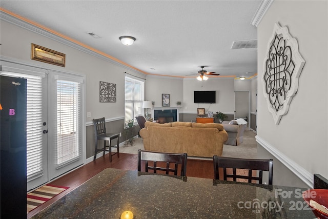 living room with ornamental molding, a fireplace, and visible vents