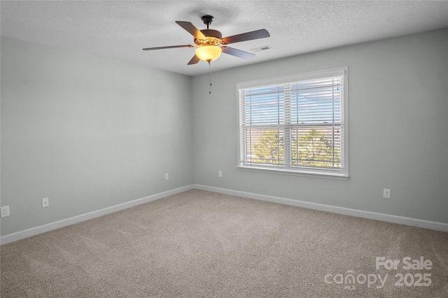 empty room featuring baseboards, visible vents, a ceiling fan, carpet, and a textured ceiling