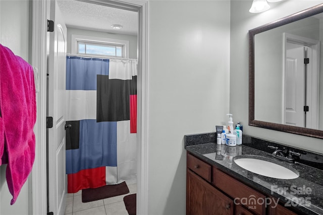 bathroom with curtained shower, tile patterned flooring, a textured ceiling, and vanity