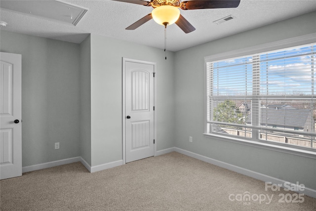 unfurnished bedroom with carpet, visible vents, a ceiling fan, a textured ceiling, and baseboards